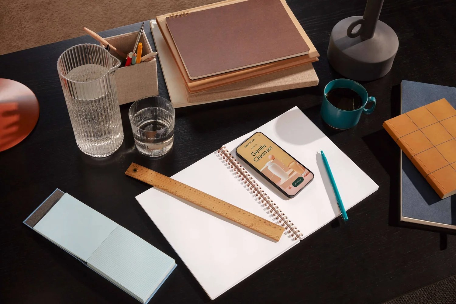 Desk with notebook, ruler and a phone showing an app