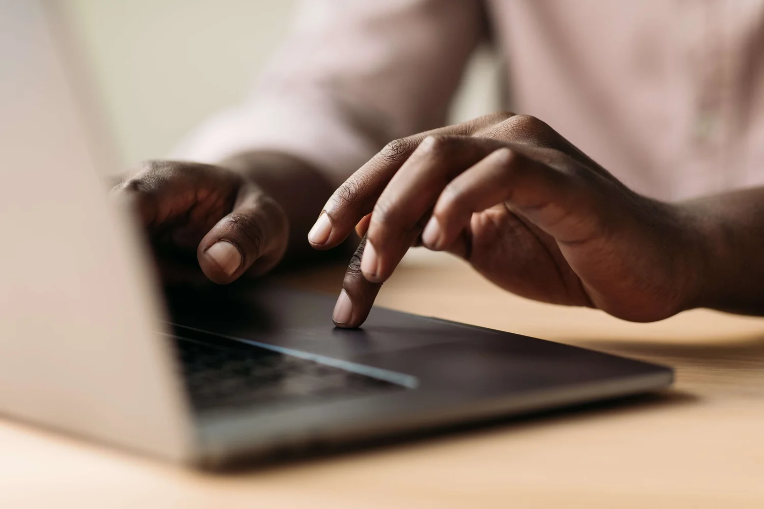 Hands typing on a laptop