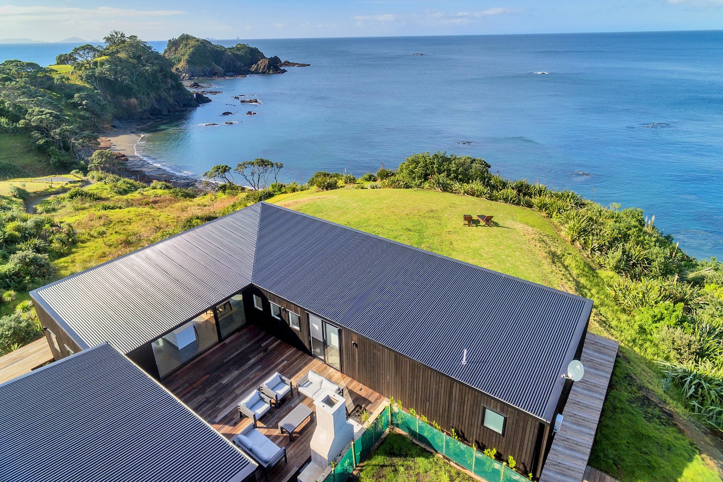 Aerial view of the house on the clifftop lawn above the bay at Tutukaka
